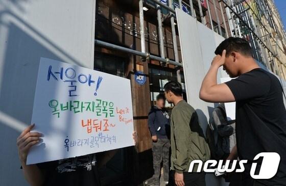 본문 이미지 - 17일 오전 서울 서대문구 옥바라지 골목 구본장 여관에 대한 명도 집행이 실시됐다. 이날 오후 옥바라지골목보존대책위 관계자가 철거현장 앞에서 철거 반대 피켓을 들고 있다. 2016.5.17/뉴스1 ⓒ News1 박지혜 기자