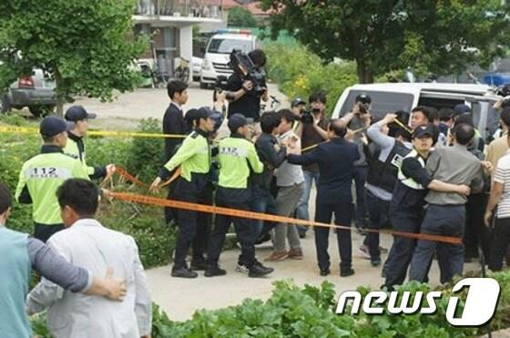 본문 이미지 - 29일 오전 10시 30분께 충북 증평군 증평읍 한 마을에서 진행된 80대 할머니 성추행 살인사건 현장검증이 끝난 뒤 유족과 주민들이 피의자 신모씨의 얼굴공개 등을 요구하며 거칠게 항의하고 있다. ⓒ News1 김용빈 기자