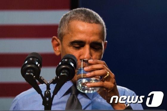 본문 이미지 - 4일(현지시간) 플린트시(市)를 방문한 버락 오바마 미국 대통령이 직접 정수된 물을 마셔보이고 있다. ⓒ AFP=뉴스1