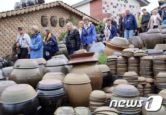 본문 이미지 - 임시공휴일인 6일 오후 울산 외고산 옹기마을에서 열린 '2016 울산옹기축제'에서 크루즈관광객들이 옹기체험을 하고 있다. (울산시 제공) 2016.5.6/뉴스1
