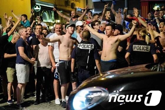 본문 이미지 - 9일(현지시간) 밤 프랑스 마르세유의 올드포트에서 영국 축구팬들이 모여있는 가운데 경찰이 경계 근무를 서고 있다. ⓒ AFP=뉴스1