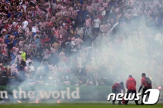 본문 이미지 - 2016 유럽축구선수권(유로 2016)이 기대 이하의 경기력, 훌리건, 잔디 상태 등으로 실망스러운 모습을 보이고 있다. 사진은 홍염이 경기장으로 날아든 지난 18일 스타드 조프루아 기샤르에서 열린크로아티아와 체코전. ⓒ AFP=News1