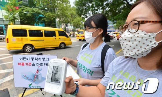 본문 이미지 -  학원들이 밀집한 서울 서초구 반포동의 한 도로변에서 환경정의 회원들이 어린이를 위한 미세먼지 안심 통학버스 만들기 캠페인의 일환으로 통학차량의 미세먼지 농도를 측정하고 있다. ⓒ News1 구윤성 기자