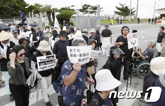 본문 이미지 - 지난달 22일 일본 오키나와현 기타나카구스촌의 주일미군 기지 '캠프 포스터' 앞에서 미군 관계자의 일본인 여성 살해사건에 항의하는 시위가 벌어지고 있다. ⓒ AFP=뉴스1