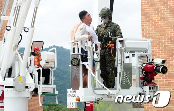 본문 이미지 - 30일 오후 전북 익산시 제7공수여단에서 실시한 재난구조부대 임무수행능력 평가 중 소방대원과 특전사 구조부대원들이 굴절차로 인명을 구조하고 있다.2016.6.30/뉴스1 ⓒ News1 문요한 기자