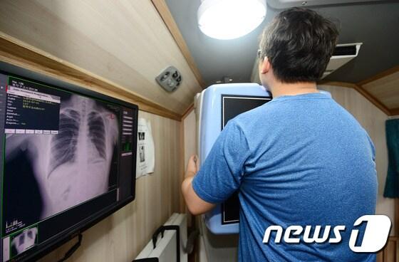 본문 이미지 - 2019년부터 20~30대 직장인 피부양자나 지역가입자 세대원이 719만명이 새롭게 국가건강검진 대상으로 포함된다. 사진은 서울 동작구 삼익아파트 관리사무소 앞에서 열린 수험생 대상 무료건강검진 행사에서 공무원 수험생이 흉부엑스레이 검사를 받고 있는 모습..2016.7.1/뉴스1 ⓒ News1 박세연 기자