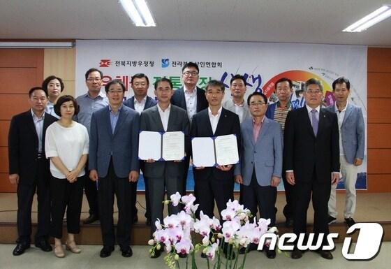 본문 이미지 - 전북지방우정청과 전라북도상인연합회가 12일 전통시장 활성화를 위한 업무협약을 체결했다.(사진제공=전북우정청)ⓒ News1