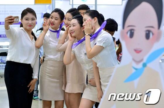 본문 이미지 - 서울 강남구 코엑스에서 지난달 14일 열린 '전문대학 엑스포'에서 스튜어디스 유니폼을 입은 학생들이 기념촬영을 하고 있다. /뉴스1 ⓒ News1
