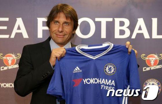 본문 이미지 - 안토니오 콘테 첼시 감독이 지난 14일 열린 기자회견에서 자신의 유니폼을 들어 올리며 포즈를 취하고 있다. ⓒ AFP=News1