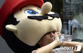 본문 이미지 - 무더위에 지친 인형 아르바이트생이 물을 마시고 있다.2016.7.20/뉴스1 ⓒ News1 안은나 기자