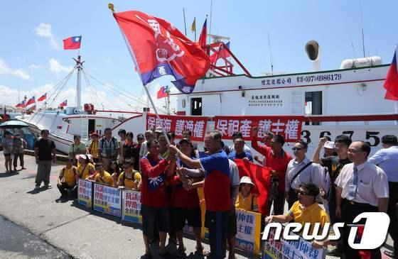본문 이미지 - 대만 어부들이 20일(현지시간) 남부 핑둥항에서 남중국해 스프래틀리 군도(중국명 난사군도)에 있는 이투아바(중국명 타이핑다오)로 출항 전에 깃발과 플래카드들을 선보이고 있다. ⓒ AFP=뉴스1 ⓒ News1 최종일 기자