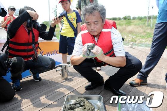 본문 이미지 - 29일 오후 광주 남구 승촌보 일원 영산강 본류에서 박창근 4대강조사위원회 위원장이 채취한 영산강 토양을 검사를위해 채취봉투에 담고 있다. 2016.7.29/뉴스1 ⓒ News1 황희규 기자