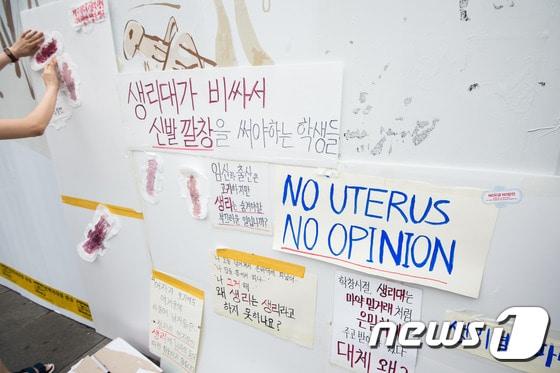 본문 이미지 - 3일 서울 종로구 인사동길에서 생리대 가격인상에 반대하는 시민들이 생리대 가격인하와 면세 등을 주장하며 벽에 물감으로 색칠한 생리대를 붙이는 퍼포먼스를 펼치고 있다. 2016.7.3/뉴스1 ⓒ News1 유승관 기자