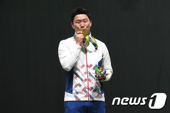 본문 이미지 - 사격 진종오가 10일(현지시간)브라질 리우데자네이루 데오도루 올림픽 사격장에서 열린 2016리우하계올림픽 50m 권총 결선에서 1위로 금메달을 획득했다. 진종오가 시상식에서 금메달에 입맞추고 있다.2016.8.11/뉴스1 ⓒ News1 이광호 기자