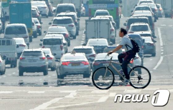 본문 이미지 -  서울 여의도공원 앞 횡단보도에서 자전거를 탄 한 시민들이 지나가고 있다.&#40;사진은 기사 내용과 무관함&#41; 2016.8.12/뉴스1 ⓒ News1 박세연 기자