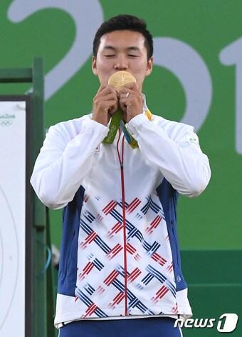 본문 이미지 - 양궁 구본찬이 12일(현지시간)브라질 리우데자네이루 삼보드로모 경기장에서 열린 2016리우하계올림픽 남자 개인 결승에서 금메달을 획득했다. 구본찬이 시상식에서 금메달에 입을 맞추고 있다.2016.8.13/뉴스1 ⓒ News1 이광호 기자