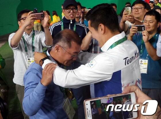 본문 이미지 - 정의선 대한양궁협회장이 2016 리우데자네이루 올림픽 양궁 남자 개인전에서 우승한 구본찬으로부터 받은 금메달을 목에 걸었다. 뉴스1 DB ⓒ News1 DB