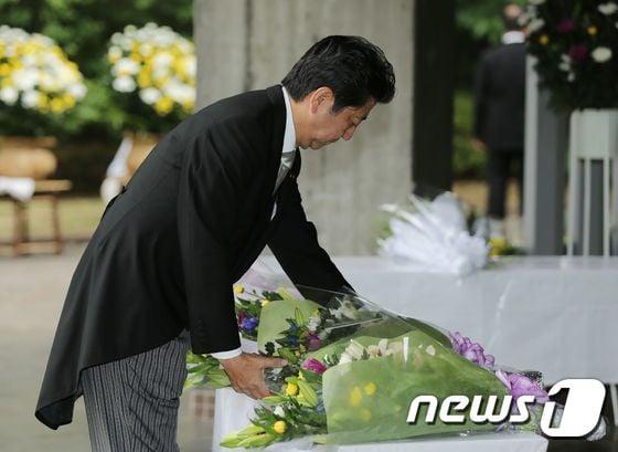 본문 이미지 - 아베 신조 일본 총리가 15일 (현지시간) 도쿄에서 종전 71주년을 맞아 치도리가푸치 국립묘지를 찾아 헌화하고 있다. 아베 총리는 이날 야스쿠니 신사는 참배하지 않고 공물만 봉납했다.ⓒ AFP=뉴스1 ⓒ News1 우동명 기자
