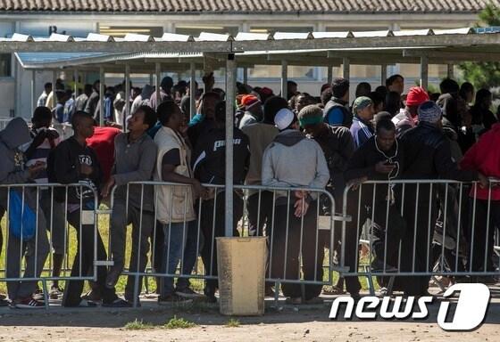 본문 이미지 - 프랑스 칼레의 ‘정글’ 난민캠프 옆 쥘 페리 구호센터에서 난민들이 배급 식량을 받기 위해 줄을 서 있다.ⓒ AFP=뉴스1 ⓒ News1 우동명 기자