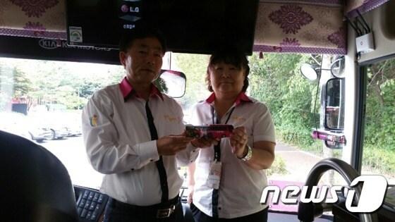 본문 이미지 - 지난 24일 오후 광명동굴 승강장에서 투어버스 기사 이광희씨(왼쪽),와 문화관광해설사 김옥연씨(오른쪽)가 모형 투어버스를 들고 인사하고 있다. ⓒ News1 조정훈 기자.