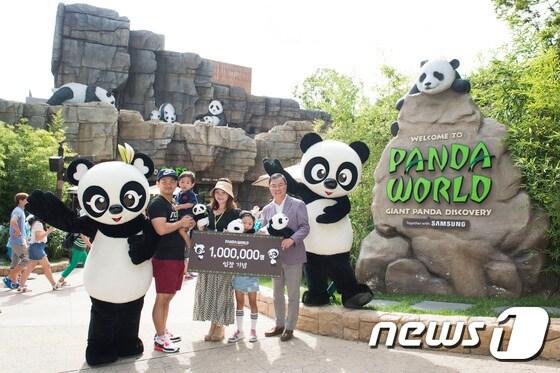 본문 이미지 - 국내 유일의 판다 체험공간 에버랜드 '판다월드'가 개관 128일 만인 지난 27일 입장객 100만 명을 돌파했다. 삼성물산 리조트사업부장 조병학 부사장(앞줄 오른쪽)과 판다월드의 100만 번째 입장 주인공인 최영기씨 가족이 기념 촬영을 하고 있다.ⓒ News1