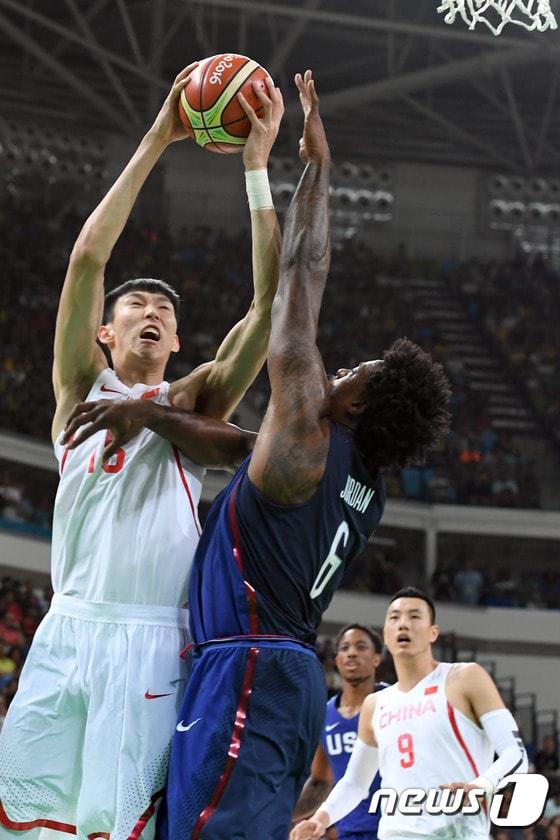 본문 이미지 - 미국 남자 농구 대표팀의 저우치(왼쪽)가 7일(한국시간) 열린 2016 리우 올림픽 남자농구 예선 A조 미국과의 경기에서 디안드레 조던(미국)을 상대로 공격을 시도하고 있다. ⓒ AFP=News1