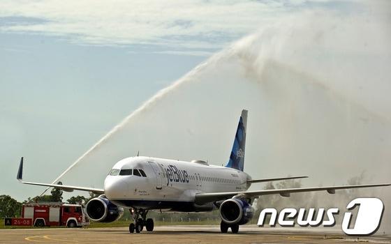 본문 이미지 - 31일&#40;현지시간&#41; 쿠바 산타 클라라 공항에 플로리다 포트로더데일 공항에서 이륙한 미국 제트블루 항공 387편이 환영의 물대포를 맞으며 착륙하고 있다. ⓒ AFP=뉴스1 ⓒ News1 배상은 기자