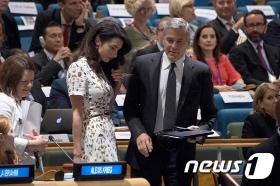 본문 이미지 - 배우 조지 클루니와 부인 아말이 20일 &#40;현지시간&#41; 뉴욕 유엔본부에서 열린 제71차 유엔총회 난민 정상회의에서 난민의 실태와 지원을 호소하고 있다.ⓒ AFP=뉴스1 ⓒ News1 우동명 기자