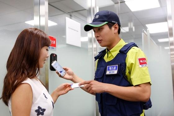 본문 이미지 - 에스원 출동요원이 고객에게 모바일 보안카드 사용법을 설명하고 있다. ⓒ News1