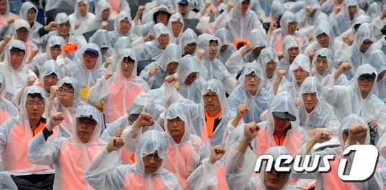 본문 이미지 - 철도 노조 파업 2일차인 28일 오후 부산 동구 부산역 광장에서 열린 '민주노총 총파업 총력투쟁 결의대회'에 참석한 노조원들이 비를 맞으며 구호를 외치고 있다. 2016.9.28/뉴스1 ⓒ News1 여주연 기자