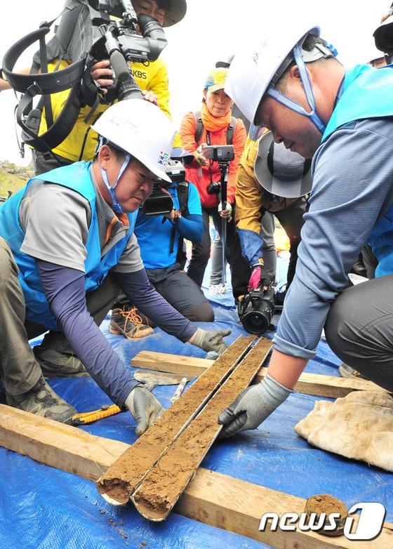 본문 이미지 - 6일 제주 한라산 백록담에서 제주한라산연구원 등 관계자들이 시추 작업을 하고 있다. 이번 시추는 백록담에 직경 8㎝, 깊이는 최고 20m의 6개의 구멍을 뚫어 자연적·인위적 요인에 의해 계속적으로 침식과 변형이 진행되고 있는 천연기념물 제182호 한라산천연보호구역에 대한 실태를 파악하기 위해 실시됐다.2016.9.6/뉴스1 ⓒ News1 이석형 기자