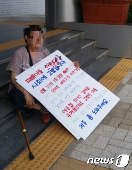 본문 이미지 - 40억 로또 당첨된 아들이 엄마를 버렸다며 양산 시청 앞에서 시위하던 노모 황모씨(87·여)와 가족들이 형사처벌을 받게됐다.지난 7월 황씨가 시청 앞에서 피켓 시위를 하다 주저앉은 모습.ⓒ News1