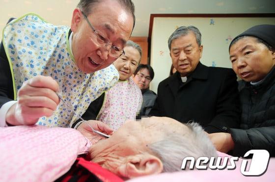 본문 이미지 - 반기문 전 유엔 사무총장이 14일 오후 충북 음성군 맹동면에 위치한 사회복지시설 꽃동네를 찾아 요양 중인 할머니에게 죽을 떠 먹여드리고 있다. 왼쪽부터 반 전 총장, 부인 유순택 여사, 오웅진 신부, 윤숙자 시몬 수녀. 2017.1.14/뉴스1 ⓒ News1 구윤성 기자