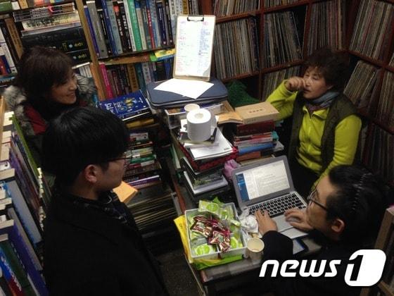 본문 이미지 - 15일 신촌 헌책방 공씨책방에서 열린 반상회에서 장화민 공씨책방 대표(맨 오른쪽)와 자발적으로 모인 시민들이 이야기를 나누고 있다.  공간이 좁아 사진에는 참석자들이 다 드러나지 않았다. .2017.1.16 ⓒ News1