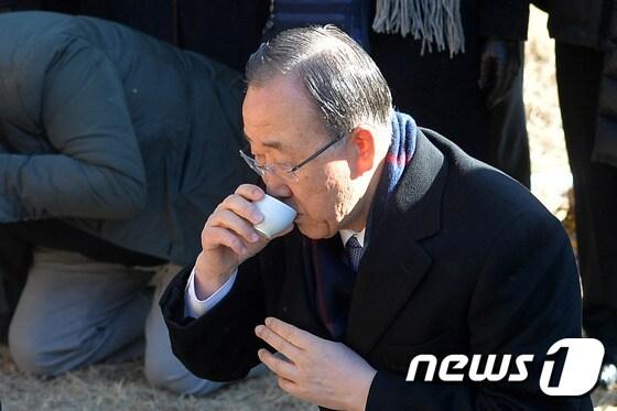 본문 이미지 - 반기문 전 유엔사무총장이 지난 14일 오전 고향인 충북 음성군 원남면 행치마을을 방문해 선친의 묘에 성묘한 뒤 음복하고 있다. 2017.1.14/뉴스1 ⓒ News1 구윤성 기자