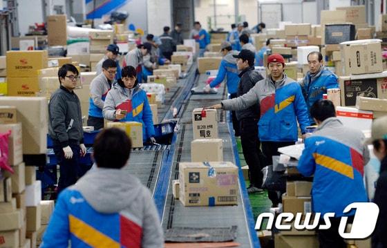 본문 이미지 - 설 연휴를 일주일여 앞둔 18일 오전 서울 금천구 CJ대한통운 가산동 터미널에서 택배기사들이 택배를 분류하고 있다. 2017.1.18/뉴스1 ⓒ News1 안은나 기자