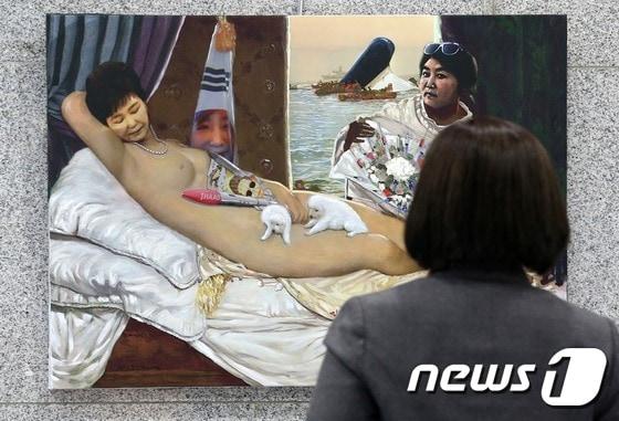 본문 이미지 - 24일 오전 국회 의원회관에서 열린 시국비판 풍자 전시회인 ‘곧, 바이!(soon bye)’전에서 방문객이 전시물을 관람하고 있다. 이 전시회에서 논란이 된 박근혜 대통령의 세월호 7시간 행적 풍자 누드화.  2017.1.24/뉴스1 ⓒ News1 손형주 기자