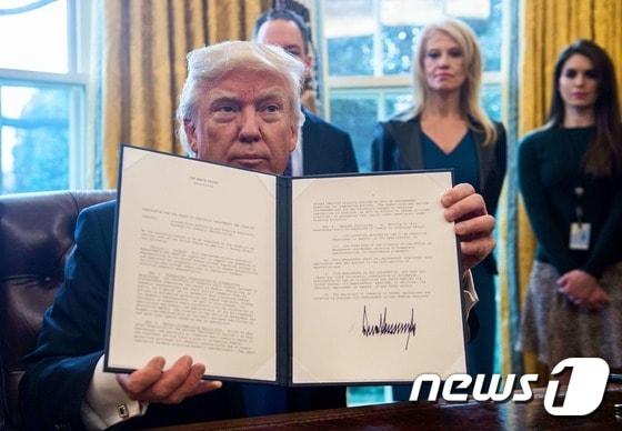 본문 이미지 - 도널드 트럼프 미국 대통령이 지난 2017년 1월 24일&#40;현지시간&#41; 워싱턴 백악관에서 ‘키스톤 XL 송유관’과 ‘다코타 대형 송유관’ 등 2대 송유관 신설을 가능하게 하는 행정명령에 서명한 뒤 보여주고 있다. 트럼프 대통령의 행정명령은 환경·에너지 문제에서 ‘오바마 업적 지우기’의 신호탄이자 자신의 대선공약 이행으로 보인다. ⓒ AFP=뉴스1 ⓒ News1 우동명 기자