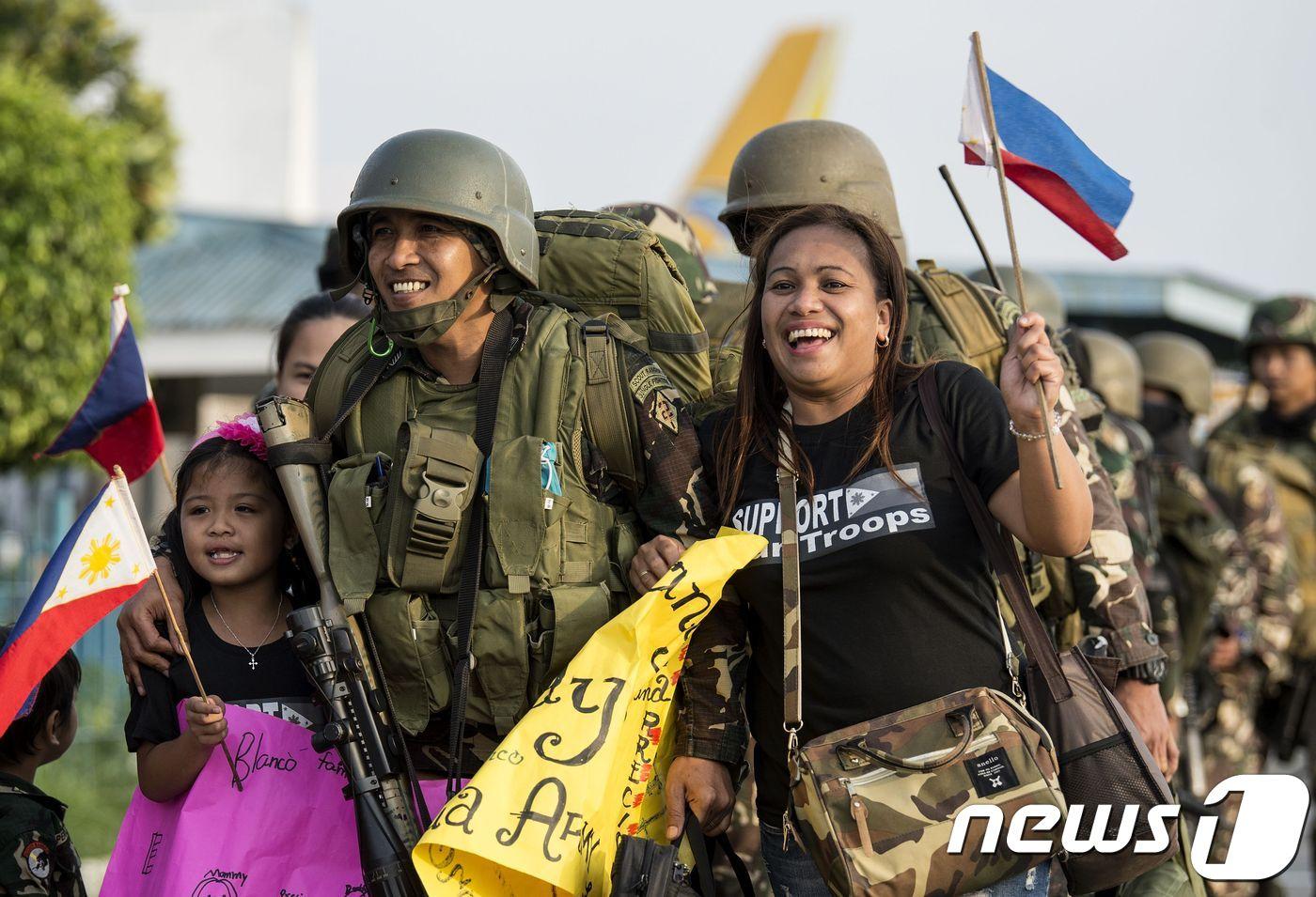 테러리스트와의 전투를 마치고 마닐라로 돌아온 필리핀 군을 가족들이 환영하고 있다. 필리핀 국방부는 23일(현지시간) 지난 5개월간 진행된 마라위 대(對) IS 전투가 종료됐다고 했다. ⓒ AFP=뉴스1