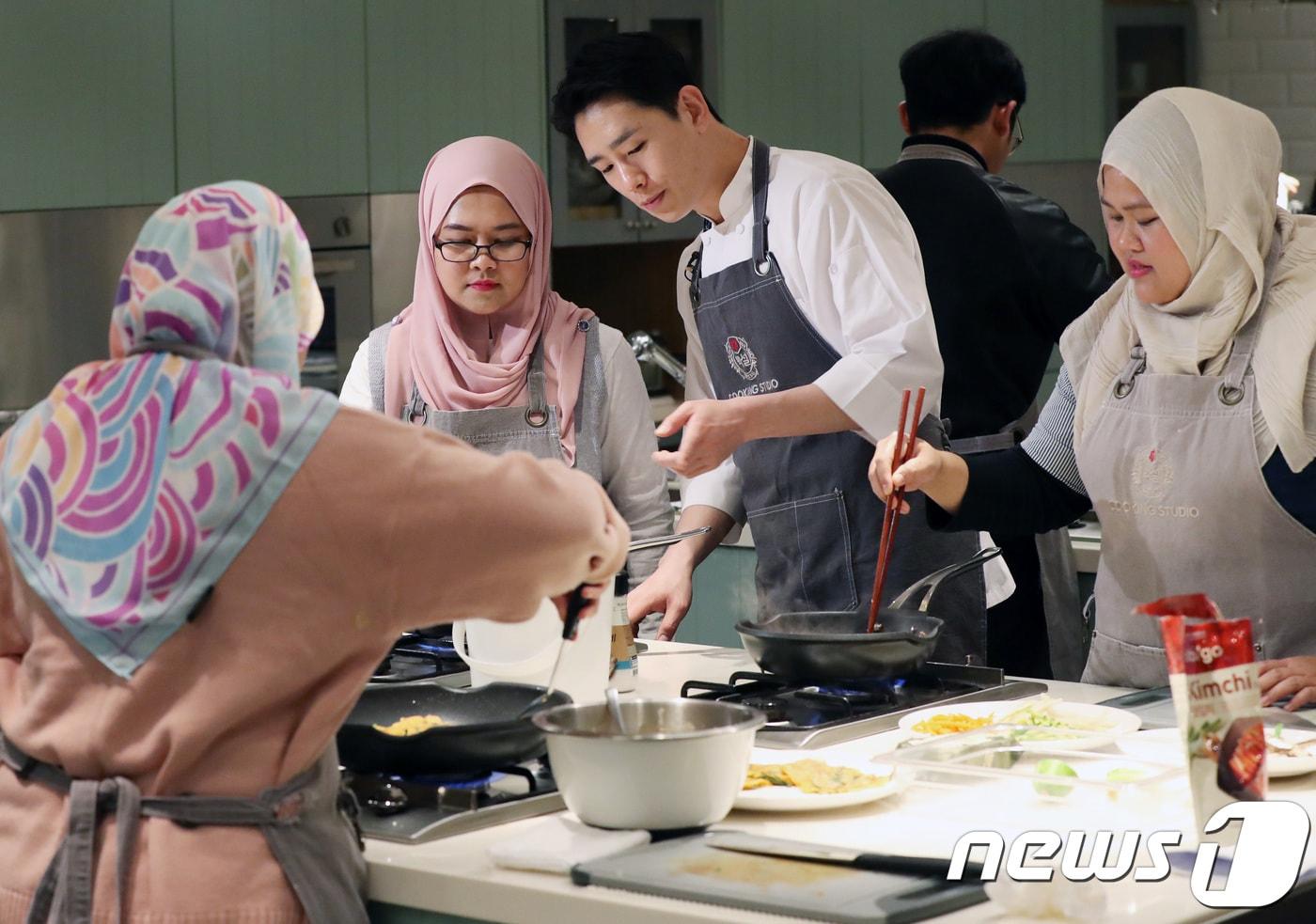 사진은 서울 중구 CJ제일제당 쿠킹클래스에서 열린 &#39;할랄식 K-food 쿠킹클래스&#39;에서 무슬림 관광객들이 최광호 요리사의 도움으로 한국 음식인 비빔밥과 김치전을 만들고 있는 모습이다. 2017.10.26/뉴스1 ⓒ News1 