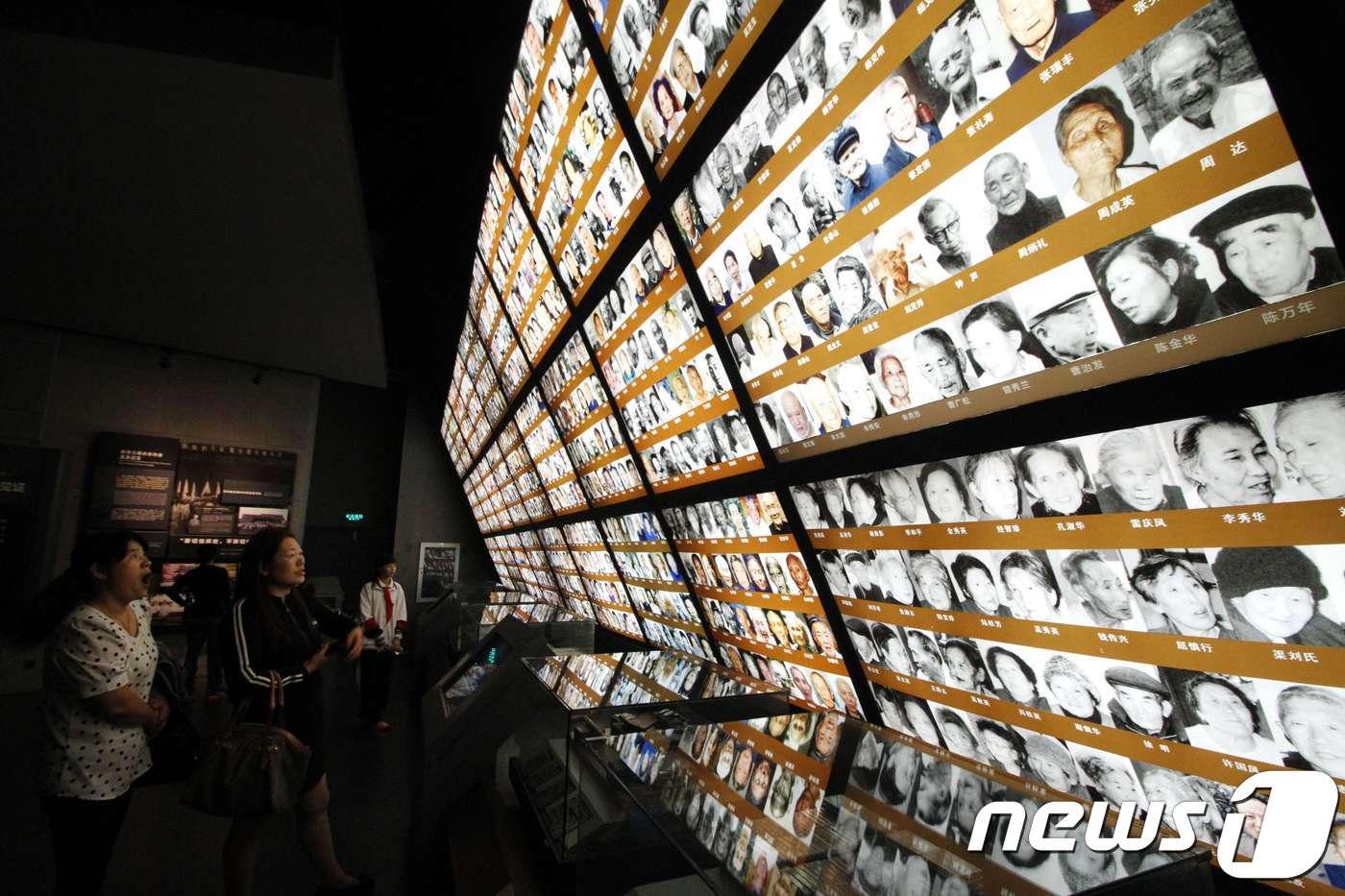 본문 이미지 - 중국 난장의 난징 대학살 기념관 벽면에 붙어 있는 학살 당시 생존자들의 사진(자료사진) ⓒ AFP=뉴스1