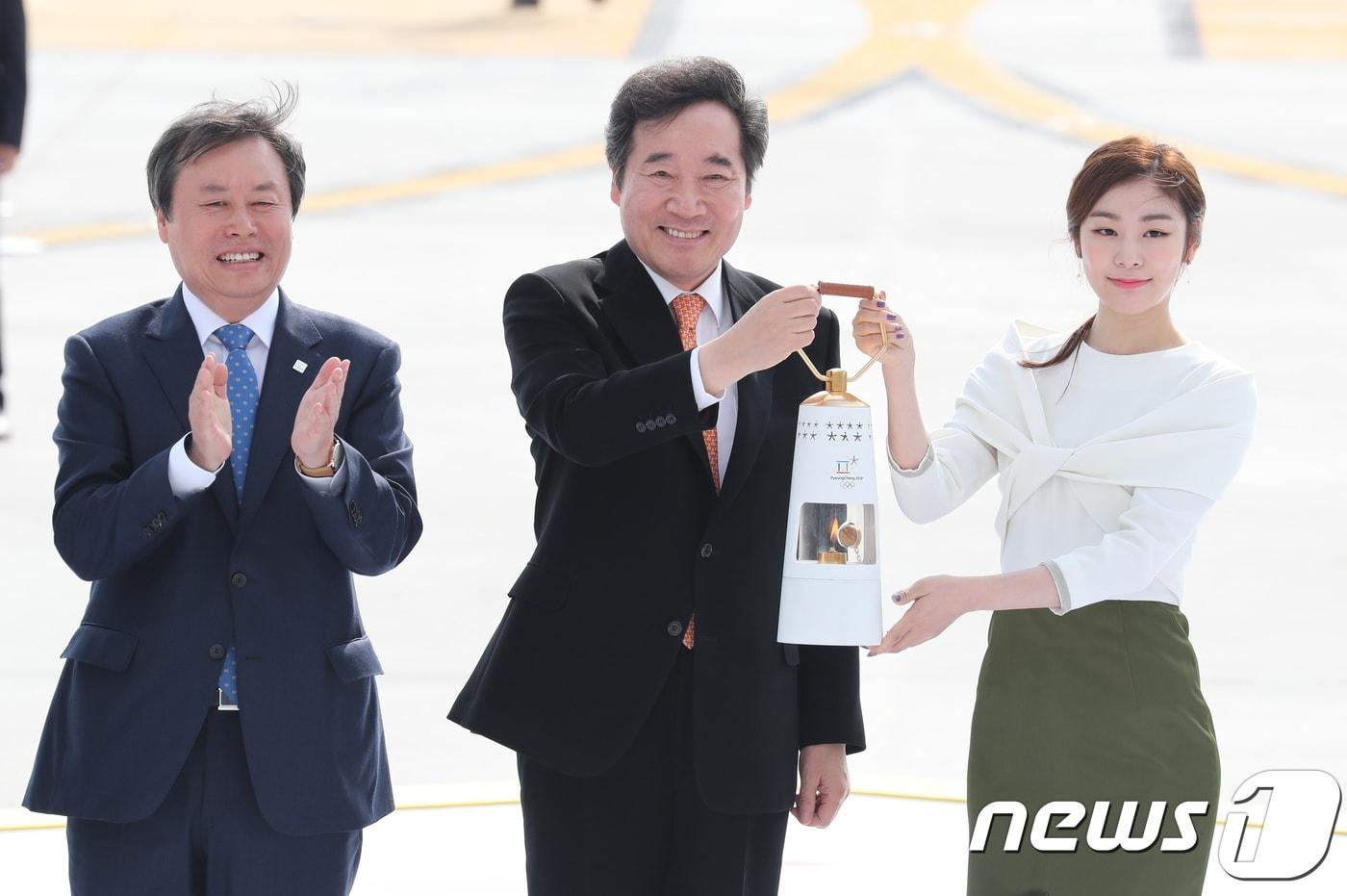 본문 이미지 - 지난해 11월1일 이낙연 국무총리와 김연아 홍보대사가 인천국제공항 제2여객터미널에 도착한 2018 평창동계올림픽 성화를 들어보이고 있다. 2017.11.1/뉴스1 ⓒ News1 유승관 기자