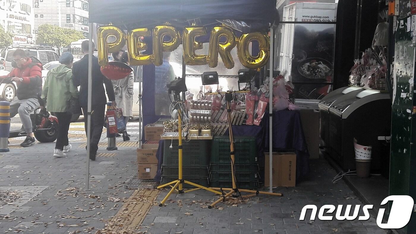 본문 이미지 - 10일 부산 연제구에 있는 한 편의점 앞 인도에  빼빼로를 팔기 위한 가판이 시각장애인용 점자 보도블럭을 침범해 설치돼 있다. 이로인해 인도를 지나던 시민들이 가판을 넘어 보행하는 불편을 겪고 있다. 2017.11.10/ 뉴스1ⓒ News1 박채오 기자