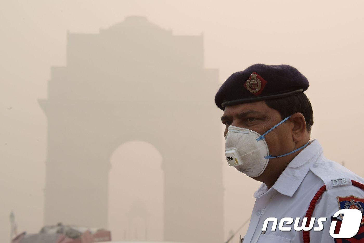 인도 의 한 경찰이 뉴델리에 있는 인디아 게이트 근처에서 마스크를 쓰고 근무하고 있다. ⓒ AFP=뉴스1 ⓒ News1 