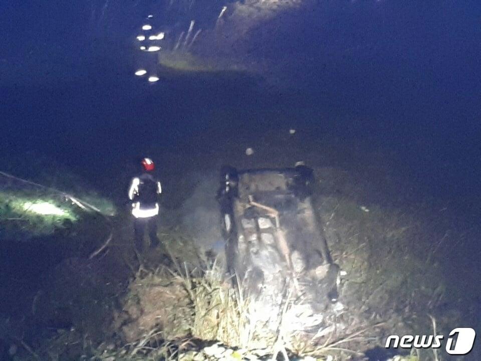 본문 이미지 - 18일 오전 6시쯤 제주시 애월읍 유수암리 평화로에서 박모씨(34여)가 몰던 경차가 도로 옆 3m 아래로 떨어지며 차에 불이나 소방관들이 진화하고 있다(제주소방안전본부 제공)ⓒ News1