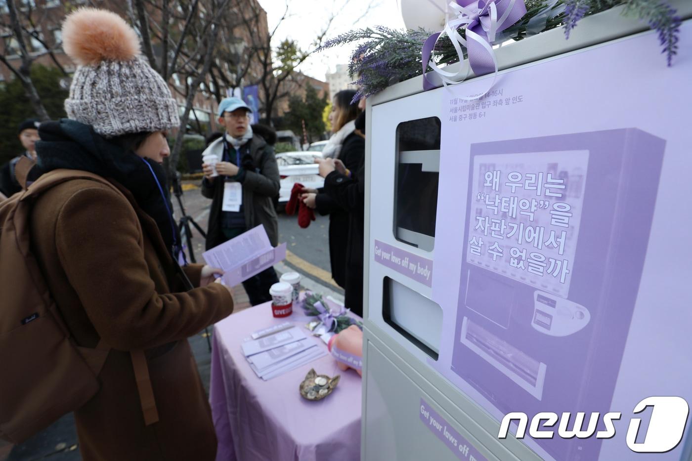 본문 이미지 - 지난 2017년 11월 서울 중구 정동길에 페미니즘 활동 단체 페미당당이 '낙태죄' 폐지를 주장하며 모형 미프진(낙태약) 자판기를 설치해 약물적 임신중단법을 소개하고 있다.  ⓒ 뉴스1 민경석 기자