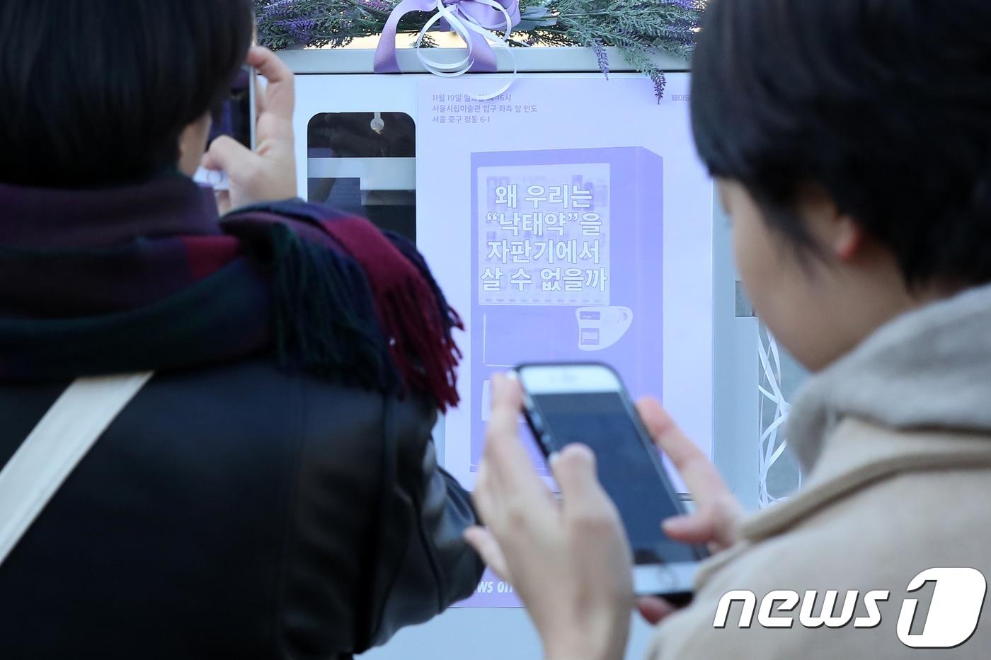 본문 이미지 - 19일 오후 서울 중구 정동길에 페미니즘 활동 단체 페미당당이 '낙태죄' 폐지를 주장하며 모형 미프진(낙태약) 자판기를 설치해 약물적 임신중단법을 소개하고 있다.  2017.11.19 ⓒ 뉴스1 민경석 기자