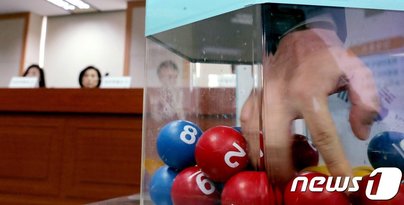 정부대전청사 병무청에서 열린 2018년도 입영대상 카투사 공개선발에서 관계자가 난수 추첨인 선발을 위해 공을 섞는 모습을 시연하고 있다. 2017.11.2/뉴스1 ⓒ News1 장수영 기자