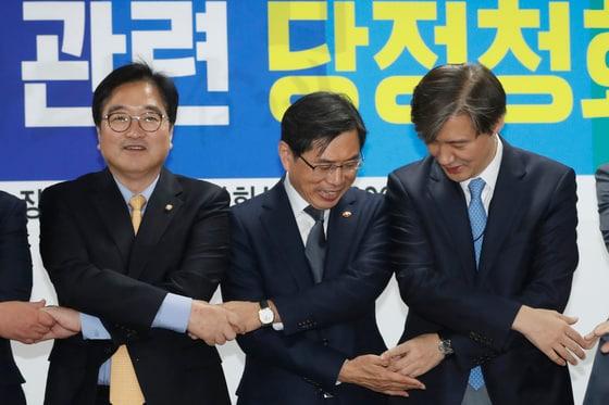 본문 이미지 - 2017년 11월 20일 우원식 더불어민주당 원내대표&#40;왼쪽부터&#41;와 박상기 법무부 장관, 조국 청와대 민정수석이  여의도 국회의원회관에서 열린 공수처설치법 제정관련 당정청회의에서 손을 맞잡고 있다. ⓒ News1 