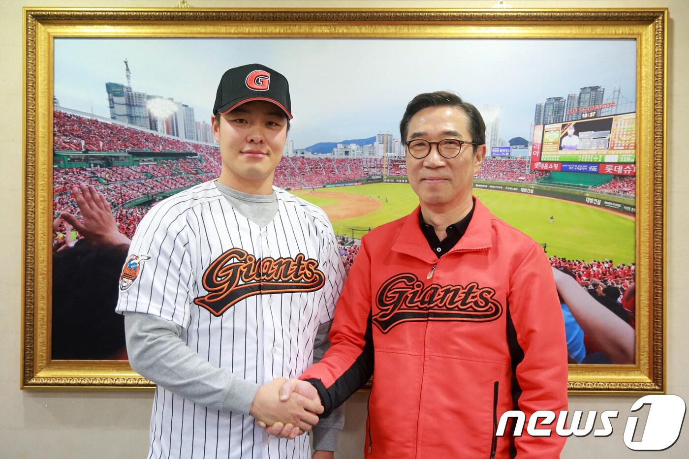 김창락 롯데 자이언츠 대표이사(오른쪽)와 민병헌이 FA 계약을 마친 뒤 악수를 하고 있다. (롯데 자이언츠 제공). ⓒ News1